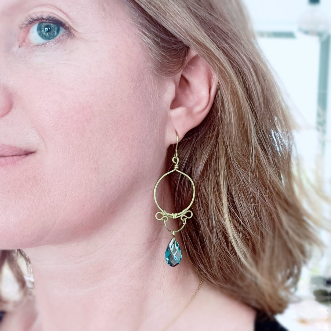 Boucles handmade en laiton brut par wirewrapping. Cristal bleu.