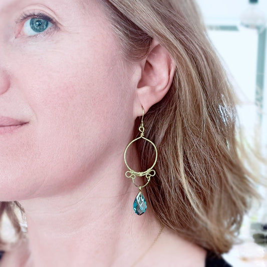 Boucles handmade en laiton brut par wirewrapping. Cristal bleu.